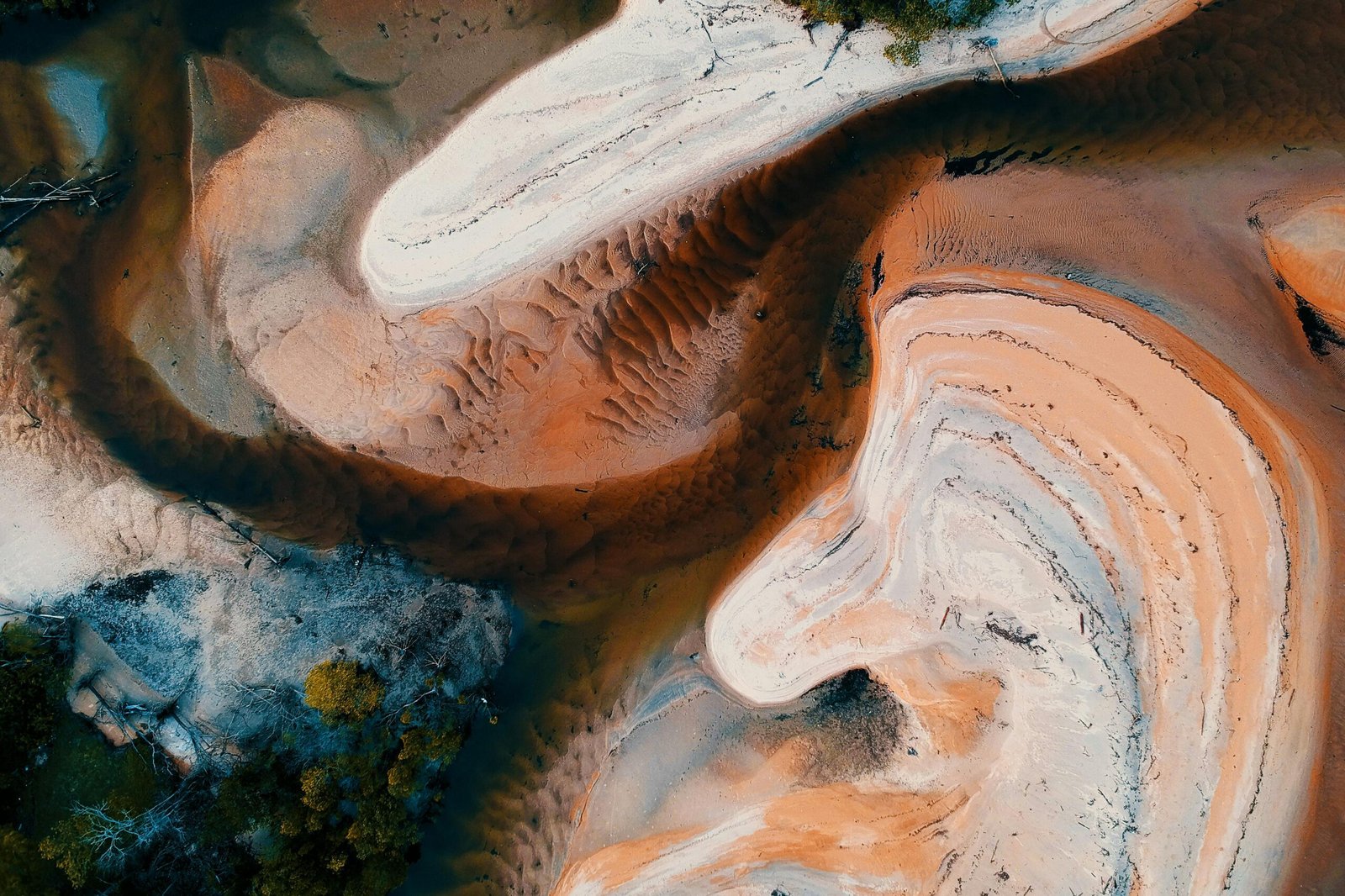 Aerial view showcasing abstract sand patterns and textures in earthy tones.